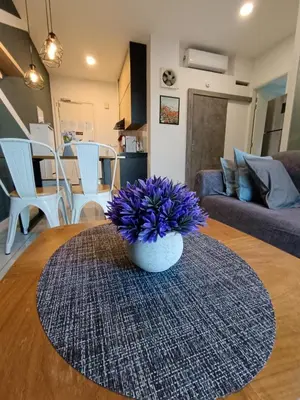 a vase with purple flowers sitting on a table in a living room at Robertson Suites Bukit Bintang with Netflix in Kuala Lumpur