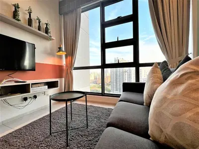a living room with a couch and a tv and a window at Eclipse Suites Robertson Bukit Bintang in Kuala Lumpur