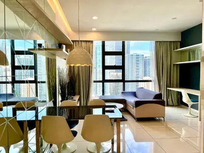 a living room with a couch and a table and chairs at Eclipse Suites Robertson Bukit Bintang in Kuala Lumpur