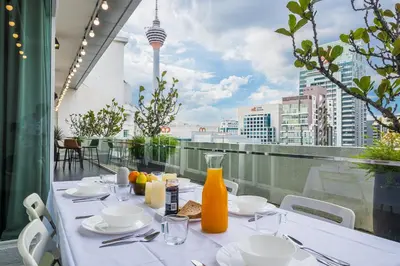 a table on a balcony with a view of a city at Starlight Penthouse 6-12Pax, 600m to Pavilion KL by Verano in Kuala Lumpur