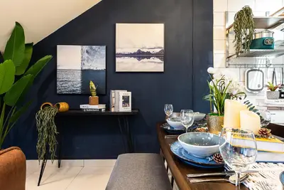 a dining room with blue walls and a table with glasses at Urban Duplex v Balcony- 2R2B Up to 7Pax, MontKiara by Verano in Kuala Lumpur