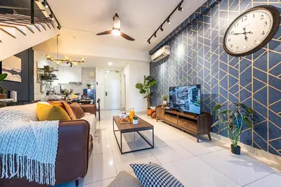 a living room with a couch and a clock on the wall at Urban Duplex v Balcony- 2R2B Up to 7Pax, MontKiara by Verano in Kuala Lumpur