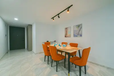 a dining room with a table and orange chairs at Eaton Residence KLCC in Kuala Lumpur