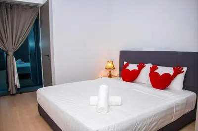 a bedroom with a bed with red chickens pillows at Eaton Residence KLCC in Kuala Lumpur