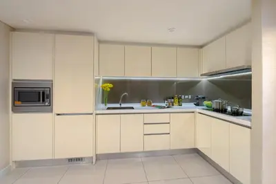 a kitchen with white cabinets and a sink at Ascott Sentral Kuala Lumpur in Kuala Lumpur