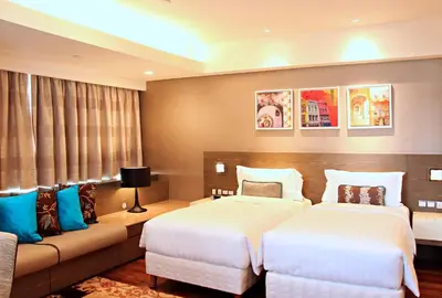 a hotel room with two beds and a couch at Ascott Sentral Kuala Lumpur in Kuala Lumpur