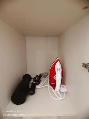 a room with a red hair dryer on a wall at UNA Serviced Apartment by manatidur in Kuala Lumpur