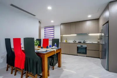 a kitchen with a wooden table and red chairs at Eaton Residence KLCC by Yemala in Kuala Lumpur