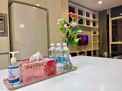 a tray with bottles of water and a vase with flowers at The Platinum KLCC By Crystal in Kuala Lumpur