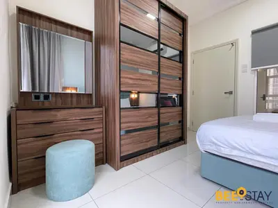 a bedroom with a large wooden closet with a bed and a blue stool at Arte Mont Kiara Studio by BeeStay in Kuala Lumpur