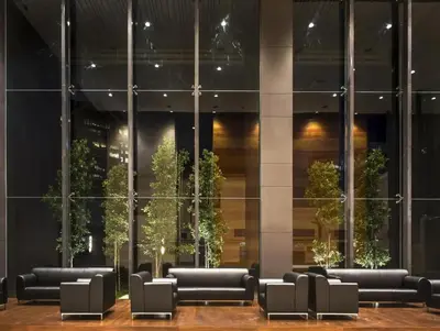 a lobby of a building with black couches and plants at Maxhome Plus at Dorsett Bukit Bintang in Kuala Lumpur