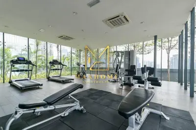 a gym with treadmills and machines in a room with windows at Maxhome Plus at Dorsett Bukit Bintang in Kuala Lumpur