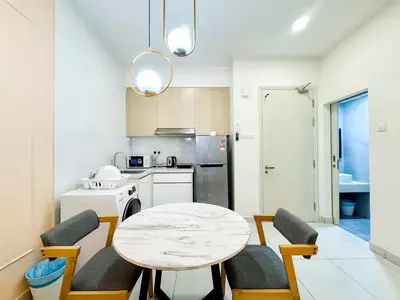 a kitchen with a table and chairs and a kitchen with a refrigerator at Arte Mont Kiara Kuala Lumpur in Kuala Lumpur