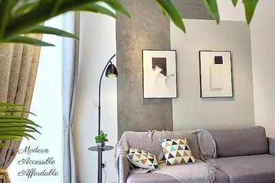 a living room with a couch and pictures on the wall at Awesome Designer Suite 3-Beds Near TRX KLCC, Next to IKEA in Kuala Lumpur