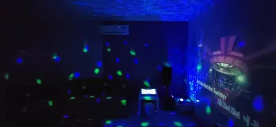 a dark room with a clock and blue and green lights at Bukit Tunku KLCC Grande Villa 11 by Vale Pine in Kuala Lumpur
