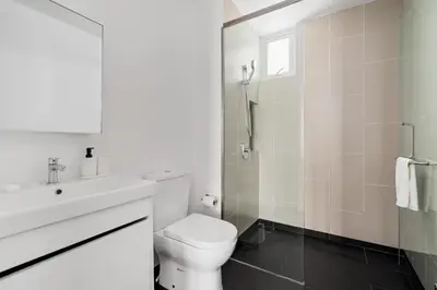 a white bathroom with a toilet and a sink at Una serviced Apartment in Kuala Lumpur