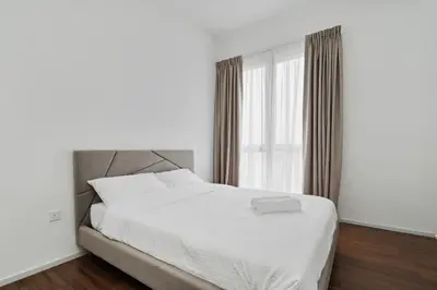 a bedroom with a white bed and a window at Una serviced Apartment in Kuala Lumpur