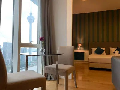 a hotel room with a table and a bed and a bedroom at Platinum Suites by Homie SkyBay in Kuala Lumpur