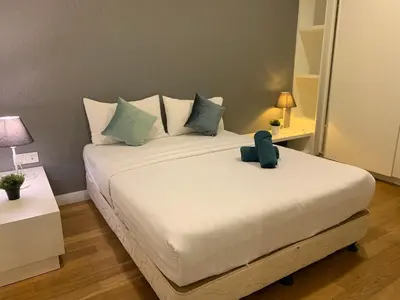 a bedroom with a large white bed with blue pillows at Platinum Suites by Homie SkyBay in Kuala Lumpur