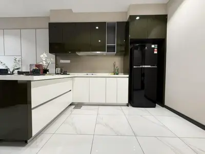 a kitchen with white cabinets and a black refrigerator at 8 Kia Peng KLCC by WSD in Kuala Lumpur