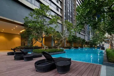 a hotel courtyard with a pool and chairs and trees at 8 Kia Peng KLCC by WSD in Kuala Lumpur