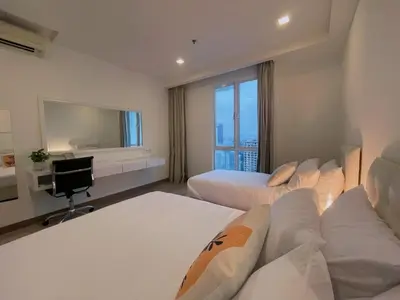 a hotel room with two beds and a television at LUX SUITES KL City Pavilion Bukit Bintang with INFINITY POOL in Kuala Lumpur