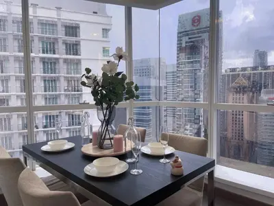 a dining room table with a view of a city at LUX SUITES KL City Pavilion Bukit Bintang with INFINITY POOL in Kuala Lumpur