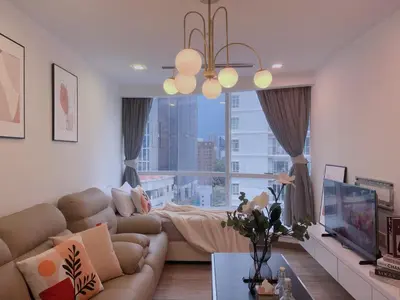 a living room with a couch and a large window at LUX SUITES KL City Pavilion Bukit Bintang with INFINITY POOL in Kuala Lumpur