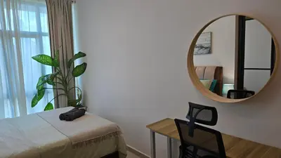 a bedroom with a mirror and a bed and a table at Aldridge Residence Coastal KLCC in Kuala Lumpur