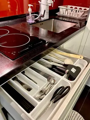 a kitchen counter with an open drawer with utensils at New Arcoris Mont Kiara Huge Balcony for 8 pax 2 BR -Garden- in Kuala Lumpur