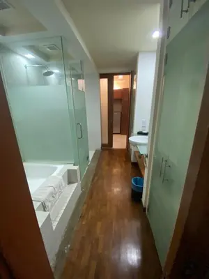 a bathroom with a shower and a glass shower stall at Peninsula Residences All Suite Hotel in Kuala Lumpur