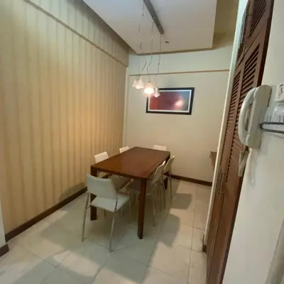 a dining room with a wooden table and chairs at Peninsula Residences All Suite Hotel in Kuala Lumpur