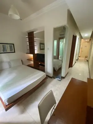 a bedroom with a bed and a desk and a mirror at Peninsula Residences All Suite Hotel in Kuala Lumpur