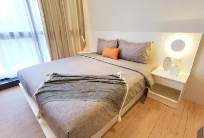 a bedroom with a large bed with an orange pillow at BTC The Curvena Bangsar South Mid Valley in Kuala Lumpur