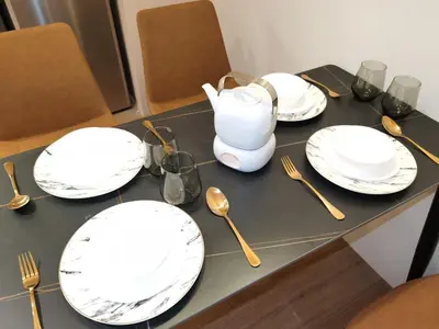 a table with white plates and forks and spoons at BTC The Curvena Bangsar South Mid Valley in Kuala Lumpur