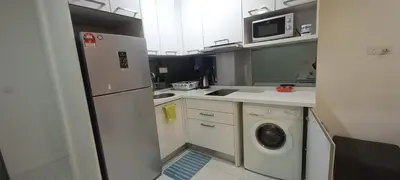 a kitchen with a refrigerator and a washing machine at ESTELAR Apartments at Mercu Summer KLCC in Kuala Lumpur