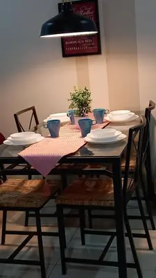 a dining room table with plates and a plant on it at ESTELAR Apartments at Mercu Summer KLCC in Kuala Lumpur