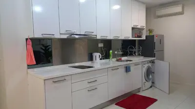 a kitchen with white cabinets and a washing machine at ESTELAR Apartments at Mercu Summer KLCC in Kuala Lumpur