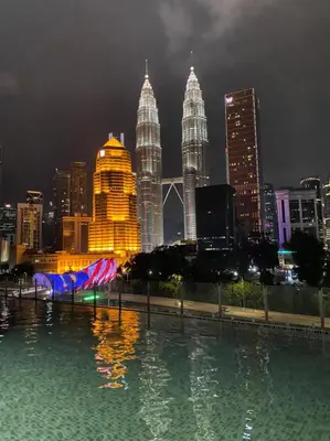 a pool of water with a city skyline at night at Legasi Kampung Baru by Twenty7 in Kuala Lumpur