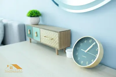 a clock next to a dresser with a plant on it at Legasi Kampung Baru by Twenty7 in Kuala Lumpur