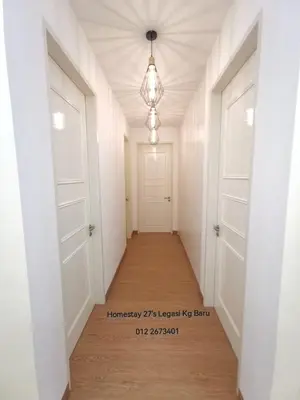 a hallway with white doors and a chandelier at Legasi Kampung Baru by Twenty7 in Kuala Lumpur