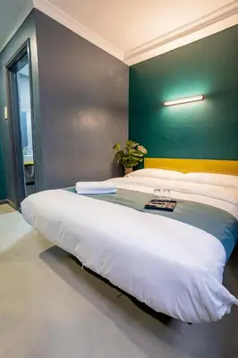 a large bed in a room with a green wall at Hotel 28 Chow Kit Kuala Lumpur in Kuala Lumpur