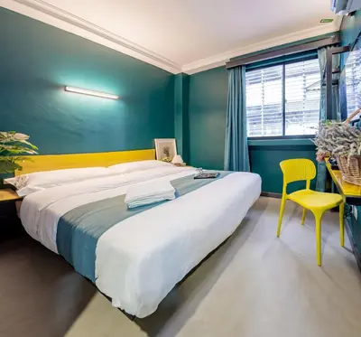 a bedroom with a large bed and a yellow chair at Hotel 28 Chow Kit Kuala Lumpur in Kuala Lumpur