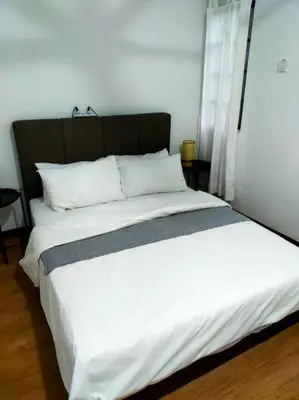 a large bed with white sheets and a black headboard at Omar's place 4 - Best view of KLCC Twin Towers. in Kuala Lumpur
