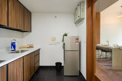 a kitchen with a refrigerator and a table in it at UNA Serviced Apartment, Sunway Velocity Kuala Lumpur in Kuala Lumpur