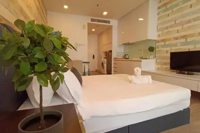 a bedroom with a white bed and a potted plant at A05 Bukit Ceylon KL Tower View Balcony Apartment in Kuala Lumpur