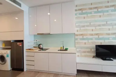 a kitchen with white cabinets and a tv on a counter at A05 Bukit Ceylon KL Tower View Balcony Apartment in Kuala Lumpur