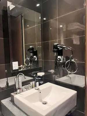 a bathroom with a white sink and a mirror at Hotel Damai Kuala Lumpur in Kuala Lumpur