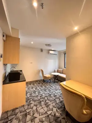 a kitchen and living room with a couch and a table at Hotel Damai Kuala Lumpur in Kuala Lumpur
