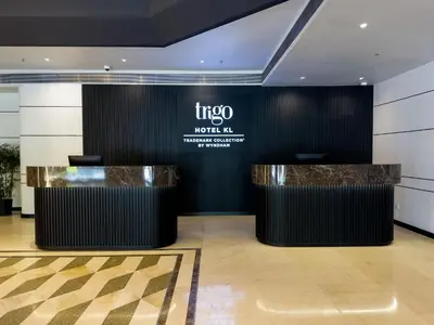 a lobby of a hotel with two counters and a sign at Trigo Hotel Kuala Lumpur in Kuala Lumpur